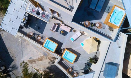 an overhead view of a pool with tables and umbrellas at Sun Stone Villas in Chania Town