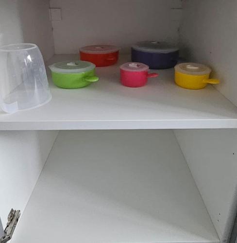four different colored bowls sitting on a shelf at Airport,NEC,JLR,Bham. Entire house 5 beds. in Kingshurst