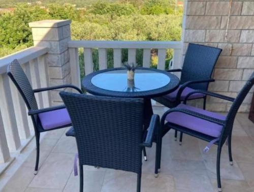 a table and chairs on a patio with a cat in it at Hetenika in Sućuraj