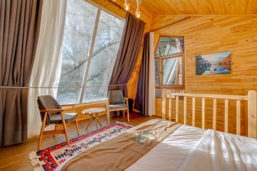a bedroom with a crib and two chairs and a window at Doceia Hotel in Kastamonu