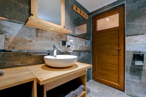 Doceia Hotel في كاستامونو: حمام مع حوض على منضدة خشبية