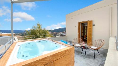 a hot tub on the balcony of a house at Sun Stone Villas in Kournás