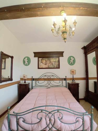 a bedroom with a bed and a chandelier at Casa Serafina trilocale con arredi d'arte e parcheggio privato in Orvieto