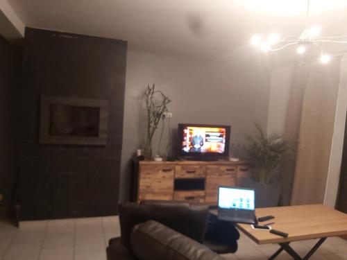 ein Wohnzimmer mit einer Couch und einem Laptop auf einem Tisch in der Unterkunft Grande maison jusqu'à 9 pers in Ézy-sur-Eure