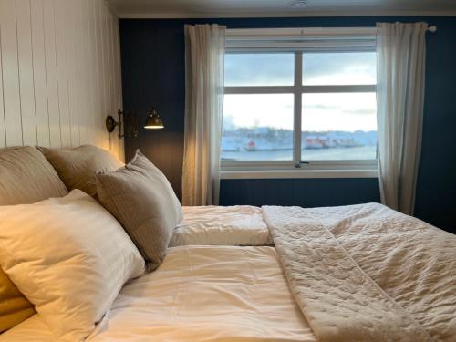 1 cama en un dormitorio con ventana en Herøy Brygge, 