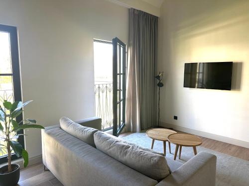 a living room with a couch and a tv at Hotel Flora Batava in Breukelen