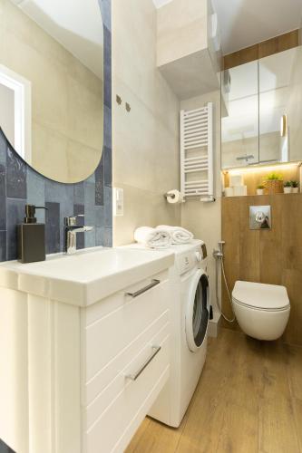 a bathroom with a white sink and a washing machine at Apartament November, A4 in Lublin