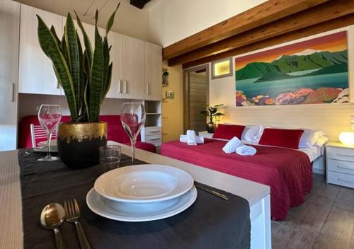 una camera con due letti e un tavolo con piatti e bicchieri da vino di Medioevo In Centro a Como