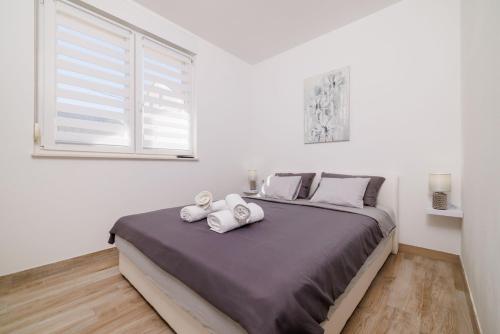 Tribalj的住宿－Apartments Margita 2，一间卧室配有一张大床和毛巾