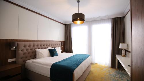 a bedroom with a large bed with a large window at Grand Hotel Belushi in Boge