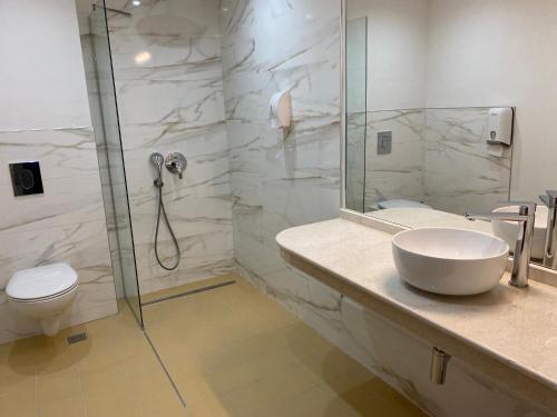 ein Bad mit einer Dusche, einem Waschbecken und einem WC in der Unterkunft Покрит Мост in Lowetsch