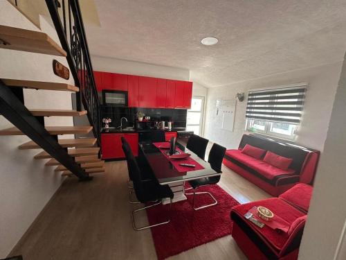 uma sala de estar com uma mesa e um sofá vermelho em Zigana Apartments em Mostar