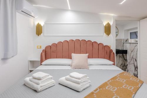 a bedroom with a large bed with towels on it at Maison 31 -Luxury Apartments in Santa Marinella