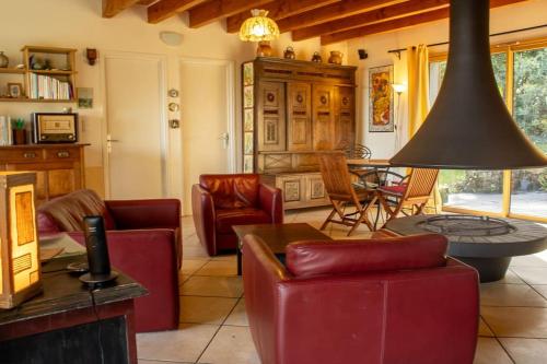 un salon avec des chaises rouges et une table dans l'établissement LA Camélia/au calme/vue mer, à Roscanvel