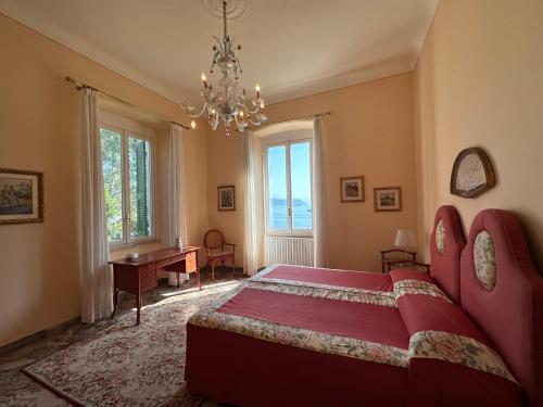 um quarto com uma grande cama vermelha e uma secretária em Villa Doria 16Pax Waterfront by VILLASRETREATS em Portovenere
