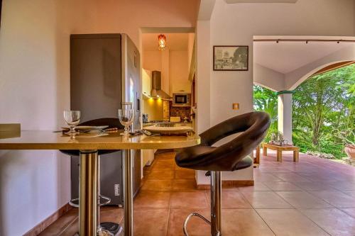 una cucina con un bar con un tavolo con bicchieri da vino di Studio Amigos a Le Diamant