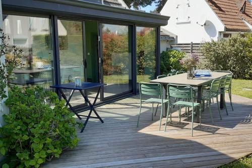 un patio avec une table et des chaises sur une terrasse dans l'établissement Maison 10 personnes à 10 minutes à pieds de la plage, à La Baule
