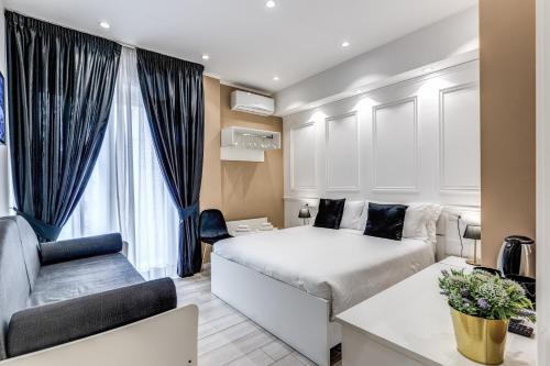 un dormitorio con una cama y un sofá en RAGGIO DI SOLE - ATAROOMS Collection, en Nápoles
