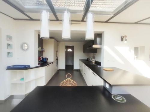 une cuisine avec des armoires blanches et un comptoir noir dans l'établissement Maison 10 personnes à 10 minutes à pieds de la plage, à La Baule