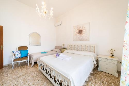 ein Schlafzimmer mit zwei Betten und einem Kronleuchter in der Unterkunft Villetta Iris by Vivimy in Taviano
