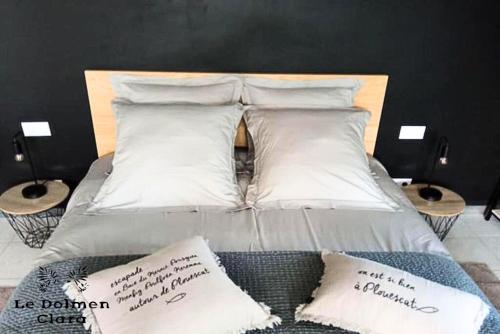 un lit avec deux oreillers dessus dans l'établissement La Casa du Dolmen Clara, balnéo privée, entre terre et mer, à Plounévez-Lochrist