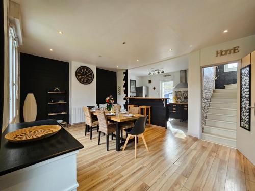 une cuisine et une salle à manger avec une table et des chaises dans l'établissement Le Doux Repos, à Étretat