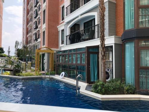 a swimming pool in front of a building at Espana Condo Resort Pattaya Sai2 in Pattaya South