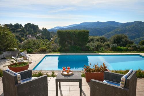 - une piscine avec 2 chaises, une table et une table dans l'établissement Sunlight Properties - Villa Belvédère, à Peymeinade