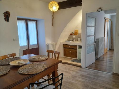 a dining room with a table and a kitchen at B&B Al Vicolo del Gallo in Varallo
