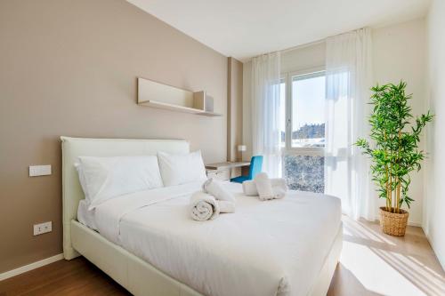 een slaapkamer met een wit bed en handdoeken bij LUVI - Occhialini 4 in Milaan