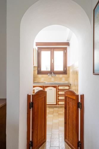 a kitchen with a sink and two wooden doors at Kazamia Apartments with Sharing Pool in Agia Fotia