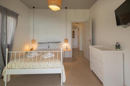 um quarto com uma cama branca e um lavatório em Vallia's Seaview & Stylish Apartments by Konnect, Nisaki em Nisakion