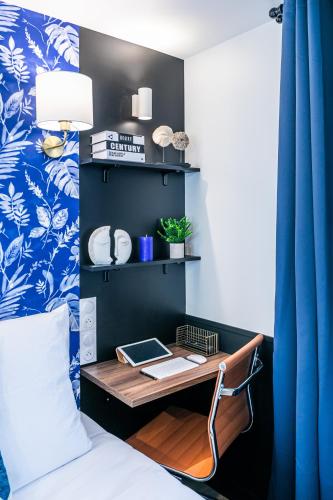 - une chambre avec un bureau à côté d'un lit dans l'établissement WS Louvre - Saint-Germain, à Paris
