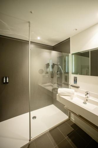 a bathroom with two sinks and a shower at Hotel & Aparthotel Alize Mouscron in Mouscron