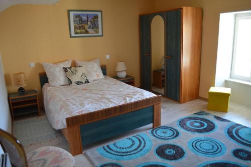 1 dormitorio con cama y alfombra azul en maison bourguignonne Le Val Thibault en Buncey