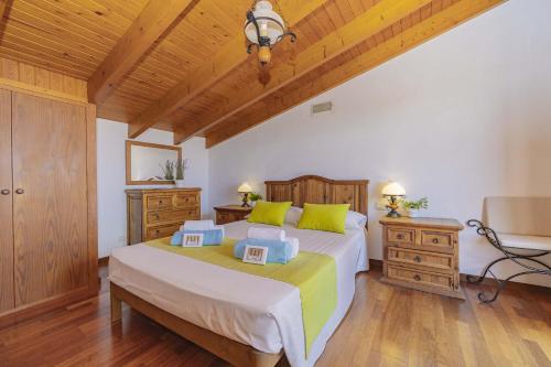 ein Schlafzimmer mit einem großen Bett und Holzdecken in der Unterkunft Villa Son Rotger in Alcúdia