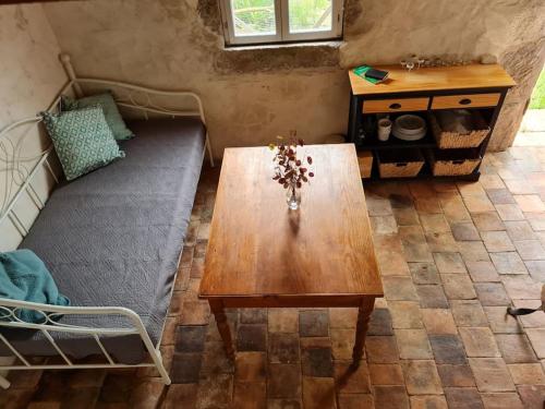 a living room with a wooden table and a couch at La Cabane du Berger in Saint-Didier-sur-Arroux