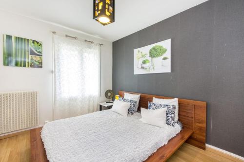 - une chambre avec un lit et un mur gris dans l'établissement Appartement charmant au cœur de Caen - 70 m² - Parking inclus, à Caen