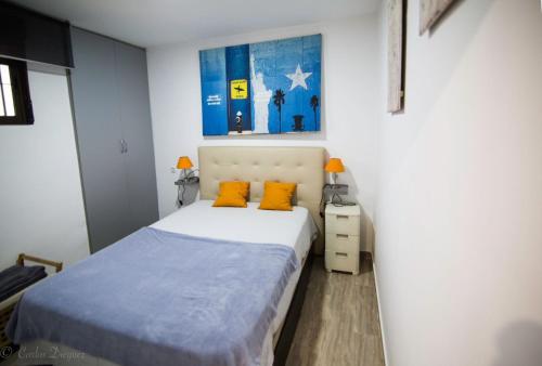 1 dormitorio con 1 cama con 2 almohadas de color naranja en Apartamento La Muralla & Casco histórico, en Córdoba