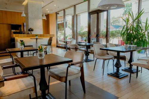 a restaurant with tables and chairs and windows at Nobel Palace Hotel in Belgrade