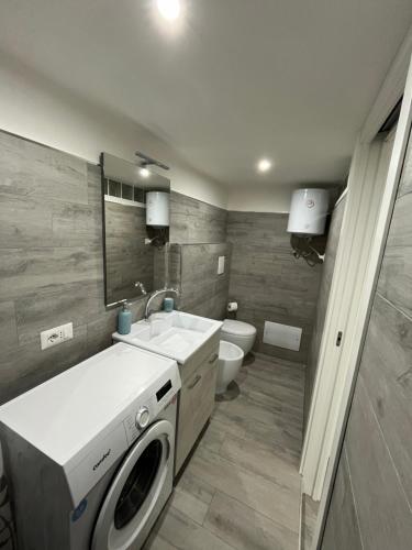 a bathroom with a sink and a washing machine at Monolocale "Sula" in Agropoli