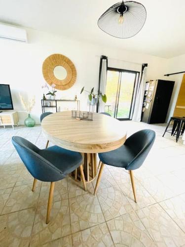 une table et des chaises en bois dans un salon dans l'établissement Maison au milieu des chevaux, à LʼIsle-sur-la-Sorgue