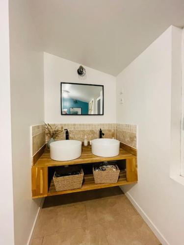 een badkamer met 2 wastafels en een spiegel bij Maison au milieu des chevaux in LʼIsle-sur-la-Sorgue