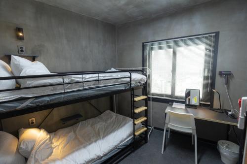 釜山的住宿－Big K House，宿舍间设有两张双层床和一张书桌。
