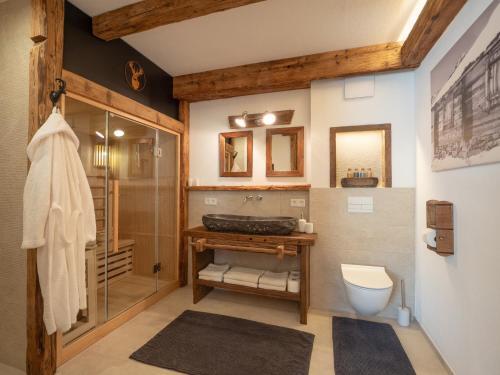 a bathroom with a shower and a toilet and a sink at Tirol Chalet Brixen in Brixen im Thale