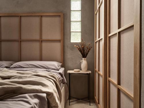 a bedroom with a bed and a vase on a table at Theros Exotica Loft Villa Contemporary 2BR W pool in Tsilivi Hills in Plános