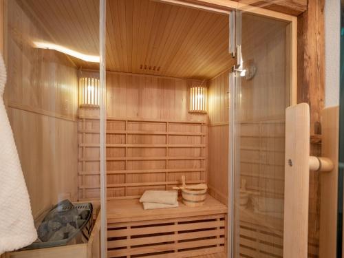 a bathroom with a sauna with a glass door at Tirol Chalet Brixen in Brixen im Thale