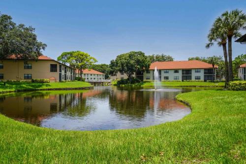 a pond in front of a building with a fountain at Luxury 2 bed and 2bath Lakefront Condo Near IMG and Anna Maria Island in Bradenton