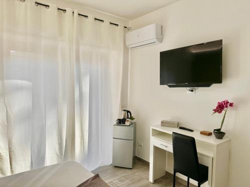 a bedroom with a desk with a tv and a window at Room Center Sorrento Baby in Sorrento