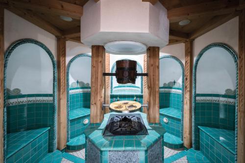 a train car with blue tiles in a room at Soldanella by Hotel Adula in Flims